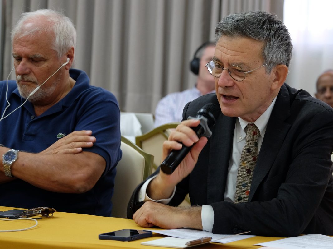 Prefect Paolo Ruffini speaking while holding a mic